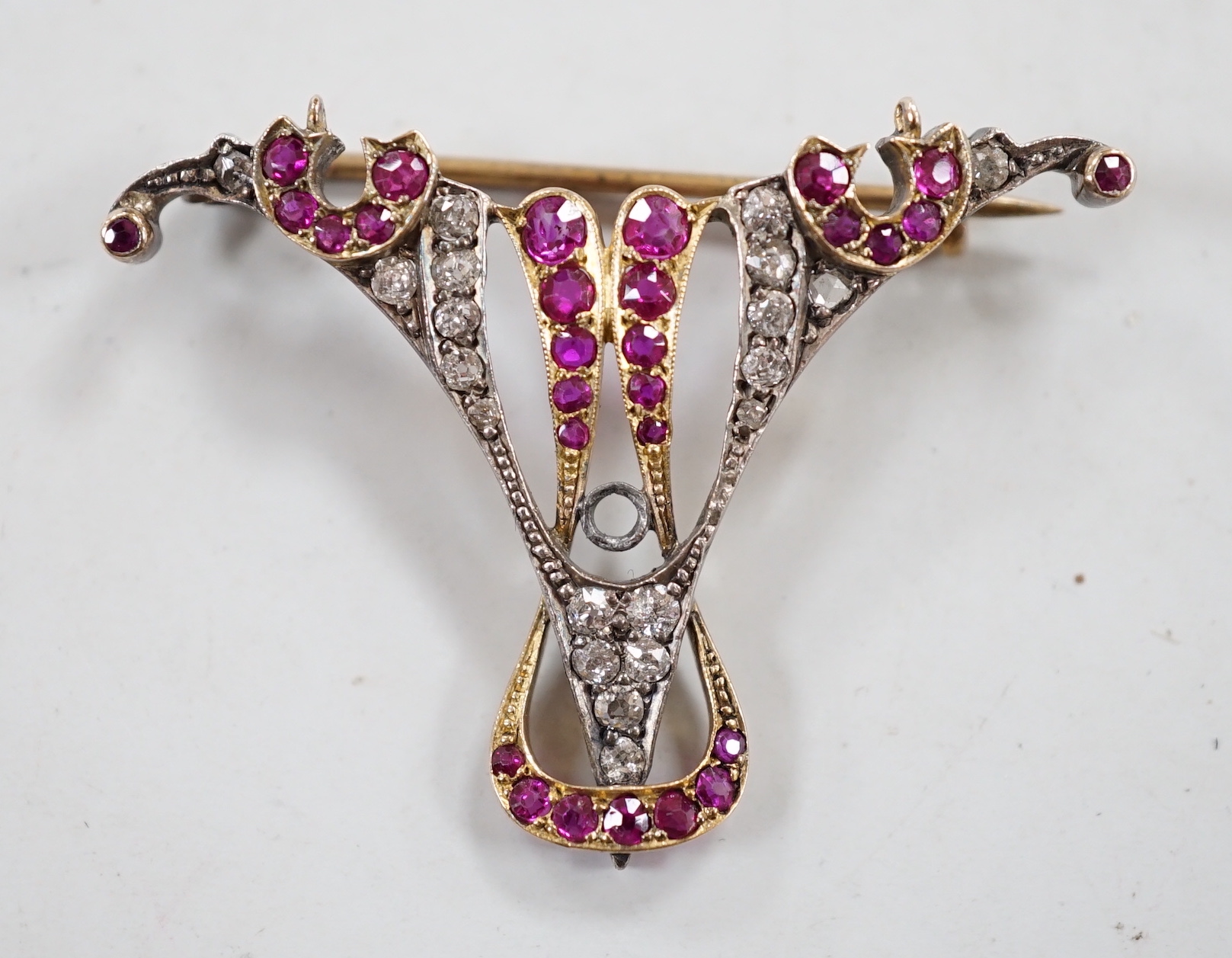 An early 20th century yellow metal, ruby and diamond cluster set brooch (stone missing), width 41mm, gross weight 4.8 grams.